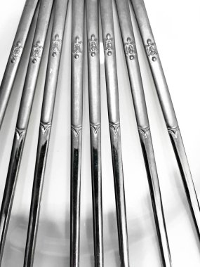 Beyaz arka planda paslanmaz çelik çubuklar, Paslanmaz çelikten yemek çubuklarının arka plan dizaynı.