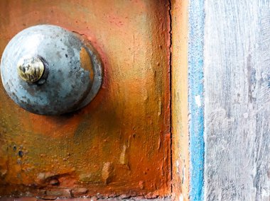 Vida detayı, Çemberli Pas, Metal, Çelik, Turuncu tahta içinde parlak cıvata. Macro, paslı metal ve perçin yüzeyi. Pas dokusu, antika ahşap kapıyı metal dekorla kapat.