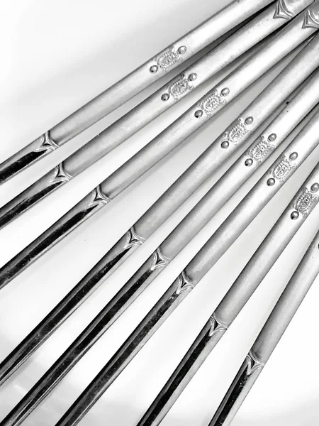 Beyaz arka planda paslanmaz çelik çubuklar, Paslanmaz çelikten yemek çubuklarının arka plan dizaynı.