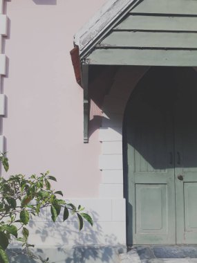 Bina duvarının arka planının kapı ve ağaçlarla olan klasik tarzı, resmin bileşimi ve güzel renklerle mükemmel bir şekilde harmanlanan binanın mimarisi bir elementtir..