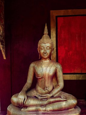 Altın Buda heykeli, altın Buda heykelinin yüzü, eski Tayland Buda heykelinin ahşap duvar arkası, din kavramı sanatı.