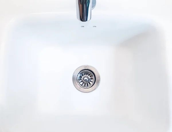 洗面台 洗面台のクローズアップ 洗面台とタップの流れ 白い洗面台のクローズアップ 洗面台の詳細 浴室のサイントイレ 水道水 シンクのタップから流れる水のクローズアップ 水道水のタップの流れ — ストック写真