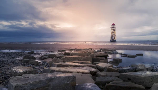 Point of Ayr Lighthouse Talacre skały plaża w forground. — Zdjęcie stockowe