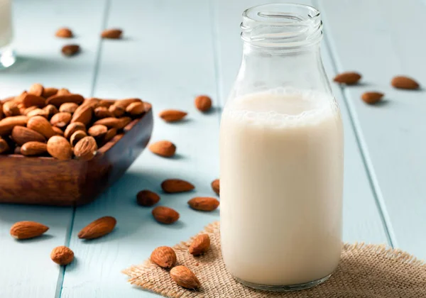 Leche de almendra y nueces en un tazón de madera Fotos de stock