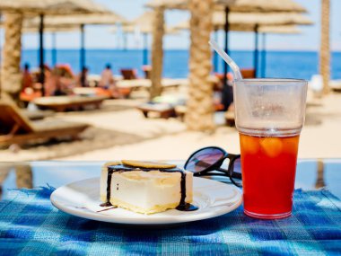 Çikolata ve mavi bir masa örtüsü ve sahilde bir kafede suyu bir bardak taze elma dilim ile vanilya köpük.