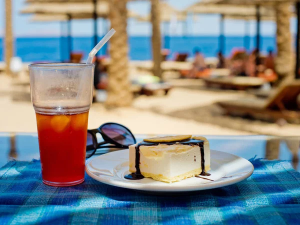 Çikolata ve mavi bir masa örtüsü ve sahilde bir kafede suyu bir bardak taze elma dilim ile vanilya köpük.