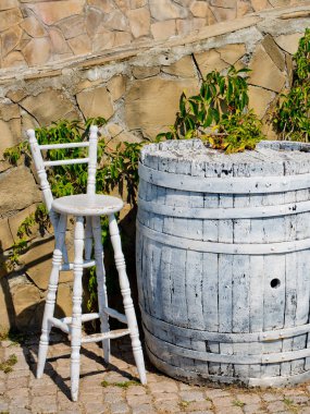 Bir tablo şeklinde bir varil beyaz ve bir sandalye boyanmıştır. Bir sokak kafe kavramını.