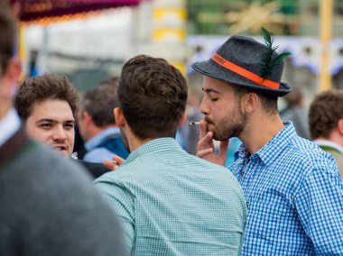 Münih, Almanya - 07 Ekim 2018: Şapkalı adam en büyük halk Festivali dünyada - oktoberfest sigara içiyor.