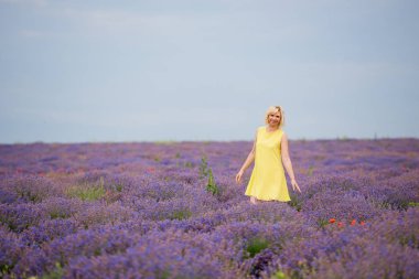 Sarı elbiseli Genç kız lavanta alana poz.