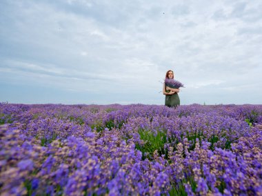 Lavanta alana poz, elinde bir buket genç kızla.
