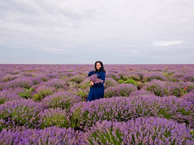 Lavanta alana poz, elinde bir buket genç kızla.