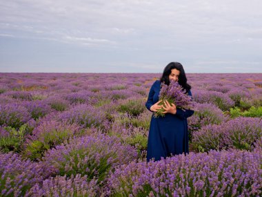 Lavanta alana poz, elinde bir buket genç kızla.