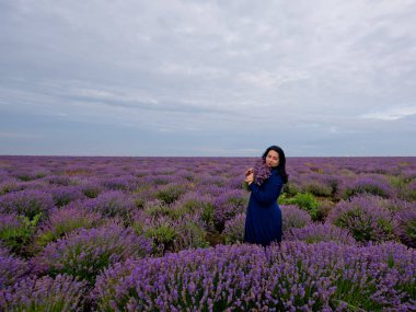 Lavanta alana poz, elinde bir buket genç kızla.