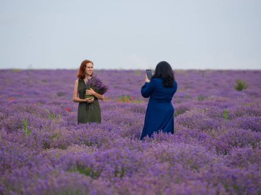 İki kız bir lavanta alanda birbirlerine fotoğraf çekmek.