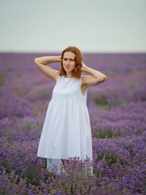 Beyaz elbiseli Genç kız lavanta alana poz.