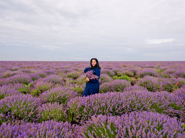 Девушка с букетом в руках, позирующая на лавандовом поле
.