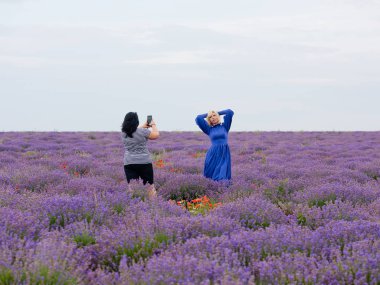 İki kız bir lavanta alanda birbirlerine fotoğraf çekmek.