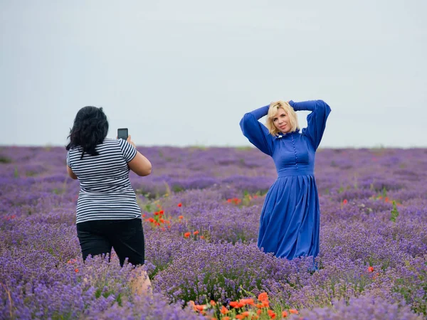 İki kız bir lavanta alanda birbirlerine fotoğraf çekmek.