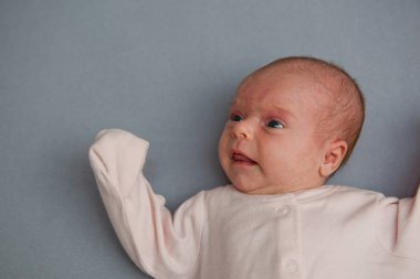 Bebek gri arka planda yatıyor.