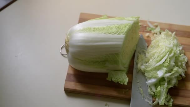 Sliced Chinese cabbage and a large knife on a cutting board. — Stock Video