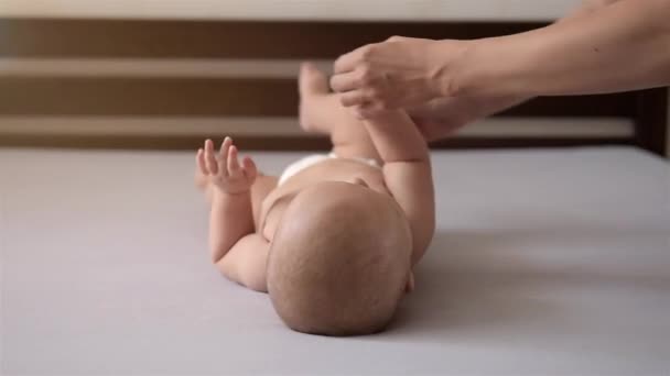 Mamma aiuta il bambino a rotolarsi sul suo stomaco . — Video Stock