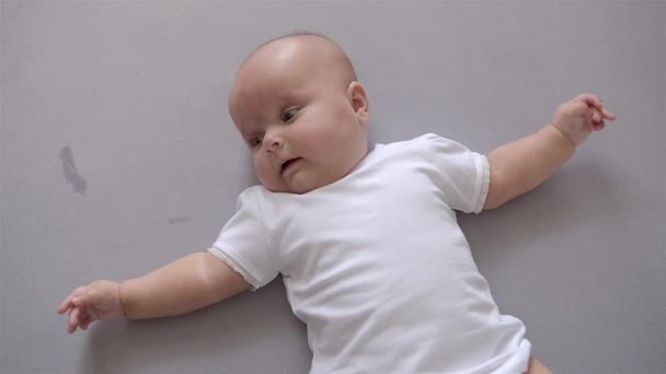 Baby ligt op zijn rug en huilen. Top View. — Stockvideo