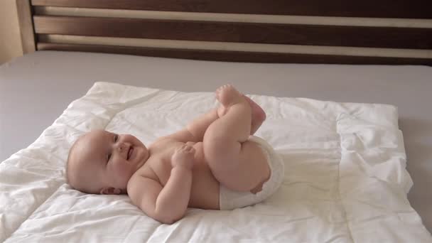 Cute baby lies on his back and moves his arms and legs. — Stock Video