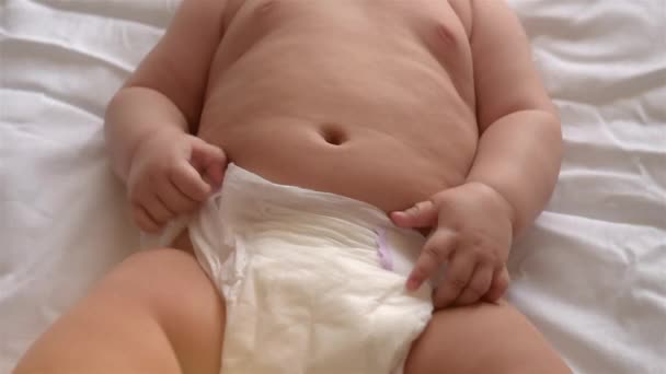 A cute baby takes off his diaper. Close-up. — Stock Video