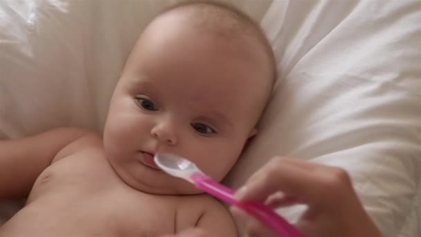 Mother give happy newborn baby spoon with medicine vitamin. Close-up. — Stock Video