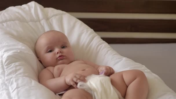 Niedliches Neugeborenes sitzt auf einem Stuhl und lächelt. — Stockvideo