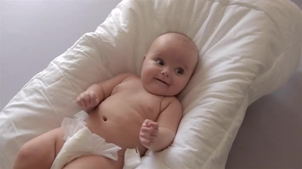 戻って白い背景に横たわっているかわいい赤ちゃん. — ストック動画