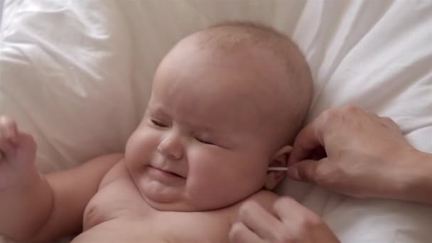 Madre limpia las orejas de su bebé recién nacido . — Vídeos de Stock