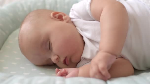 Portrait of cute baby is sleeping on the bed. Close-up. Soft focus. — Stock Video