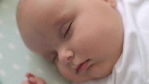 かわいい赤ちゃんの肖像画がベッドの上で寝ています。クローズ アップ。ソフトフォーカス. — ストック動画