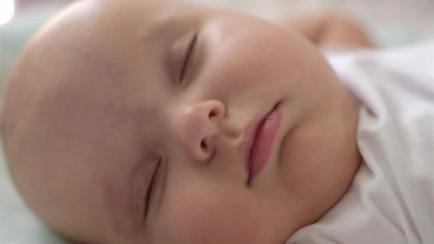 Close-up portrait of a beautiful sleeping baby in bed. — Stock Video