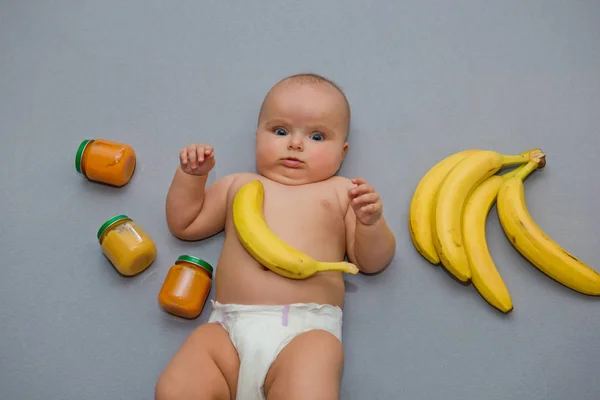 Baby Grå Bakgrund Med Bananer Och Burkar Med Barnmat — Stockfoto