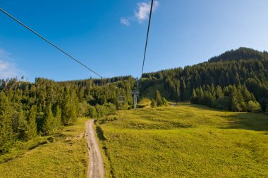 Güneşli bir günde orman ve kayak kaldırma ile dağ manzarası.