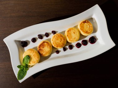 Sabah kahvaltısı var. Lokantanın ahşap arka planında süzme peynirli krep ya da peynirli börek. Yakın plan. Üst görünüm.