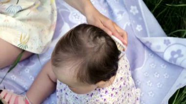 Annem küçük bir kızın saçını tarıyor. Yakın çekim..