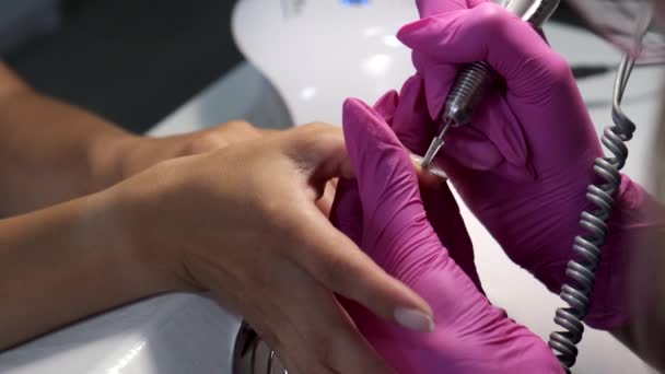 Closeup of manicurist removes gel shellac polish from client's nails using manicure machine. Slow motion. — Stock Video