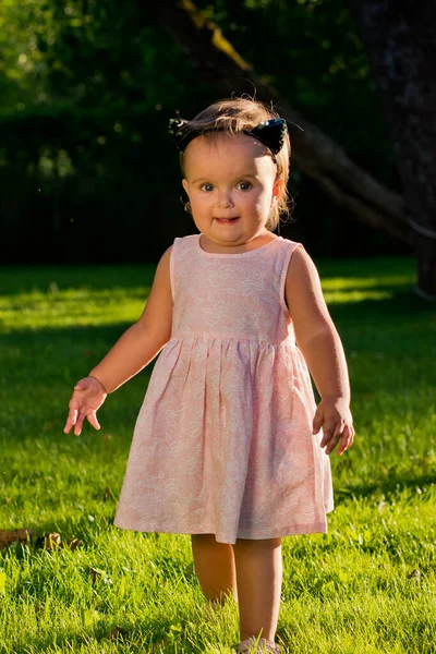 公園の芝生の上を歩いている赤ん坊の女の子 — ストック写真