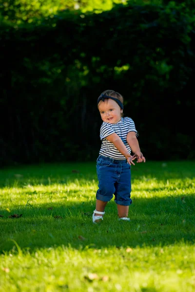 公園の芝生の上を歩いている笑顔の赤ちゃん — ストック写真