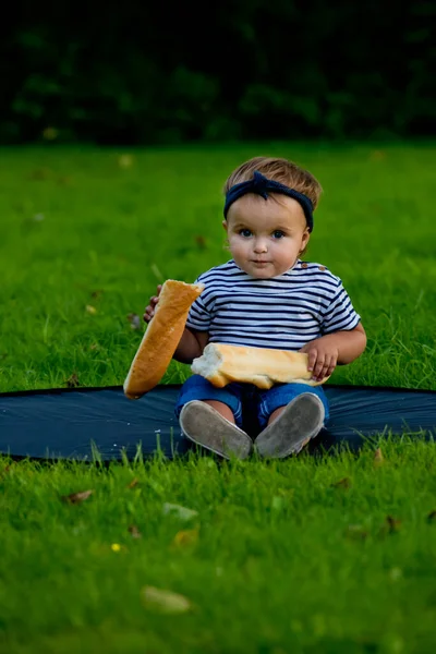 Küçük Güzel Bir Kız Çocuğu Bahçedeki Çimenlerde Oturuyor Elinde Taze — Stok fotoğraf