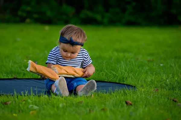 Little Pretty Baby Girl Sits Lawn Garden Holds Fresh Baguette — Stock Photo, Image