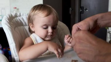 Babanın eli küçük kızı çorbayla besliyor. Yakın plan..