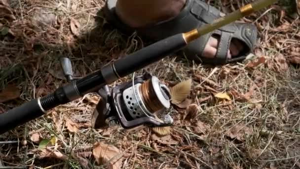 The fisherman installs the spinning rod on the fishing rack. Close-up. — Stock Video