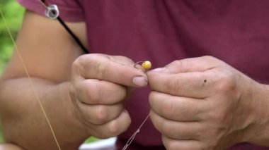 Balıkçı oltaya yemi takıyor. Yakın çekim..