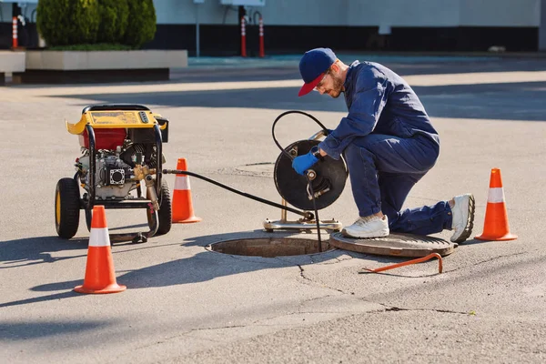 Plumber prepares to fix the problem in the sewer. Repair work on troubleshooting.