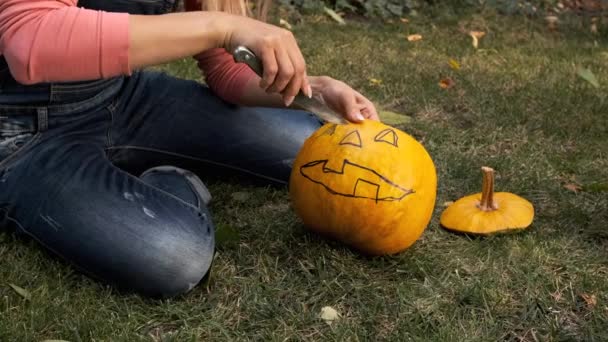 Les mains féminines sculptent une effrayante citrouille d'Halloween. Au ralenti. Lanterne Jack pour fête d'Halloween. — Video