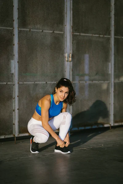 年轻的运动女性运动员鞋带鞋和准备为城市跑步和健身锻炼 积极进取的女性培训外 — 图库照片